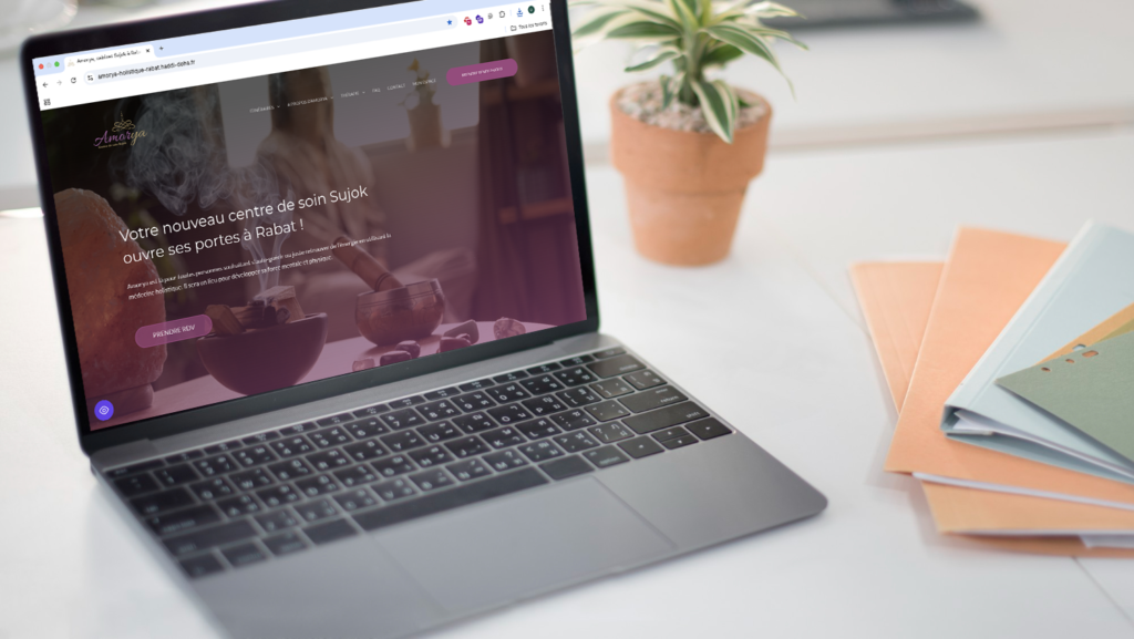 Photo d'un ordinateur sur un bureau avec le site d'Amorya affiché sur l'écran